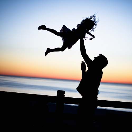 leisure activities silhouette of man throwing girl in air dance pose